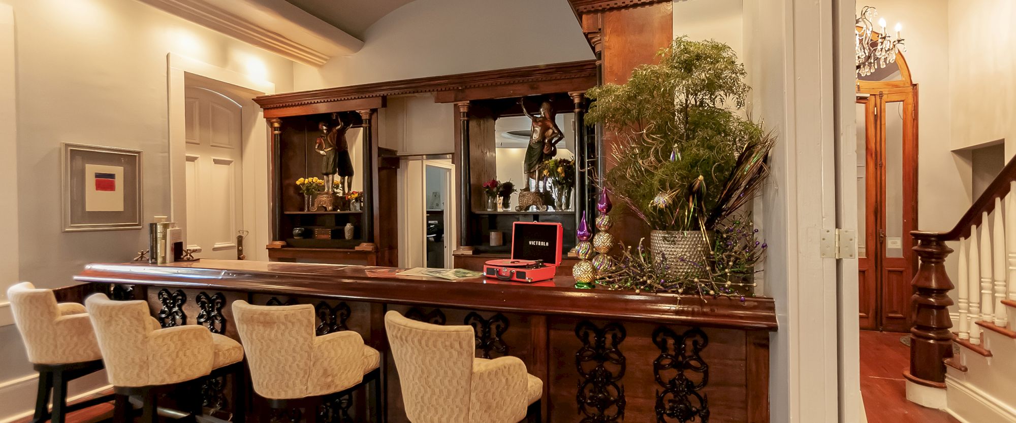 A cozy indoor bar with decorative chairs, mirrors, plants, and a record player on a wooden counter ends the serene setting.